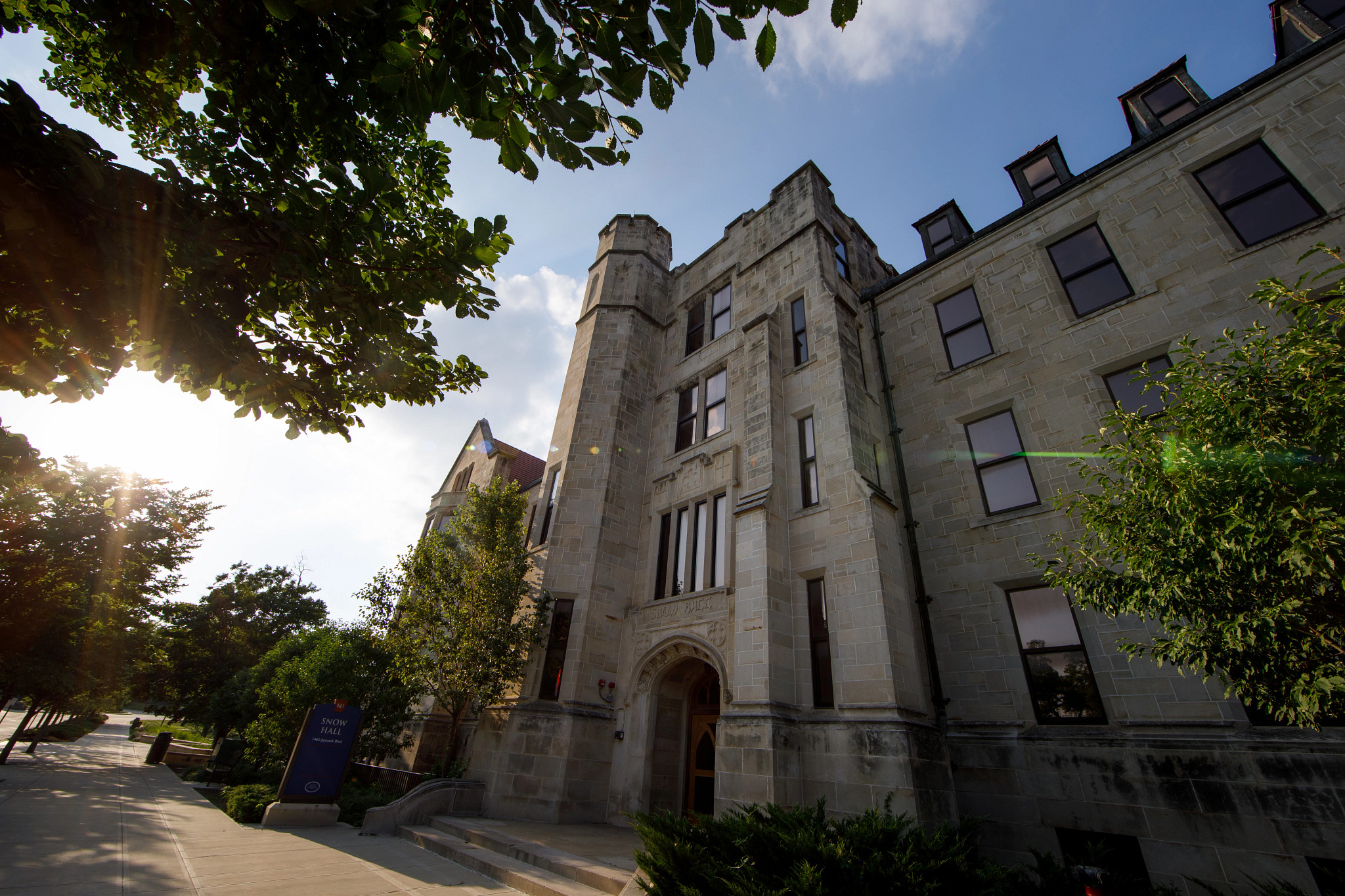 Campus building with sunlight shining through trees